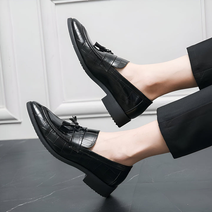 Gros plan de mocassins noirs en cuir à glands, avec un motif de crocodile, portés avec un pantalon noir élégant sur un sol en marbre. Chaussures de luxe pour hommes, style élégant., 45287072923829,45287072956597,45287072989365,45287073022133,45287073054901,45287073087669,45287073120437,45287073153205,45287073185973