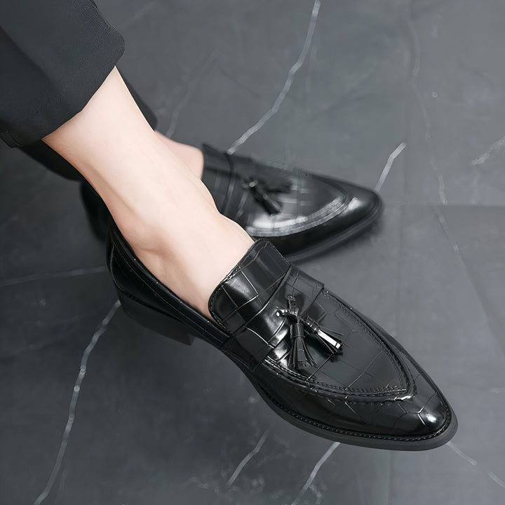 Gros plan sur des mocassins noirs en cuir verni avec des glands, portés avec un pantalon noir. Sols en marbre., 45287072923829,45287072956597,45287072989365,45287073022133,45287073054901,45287073087669,45287073120437,45287073153205,45287073185973