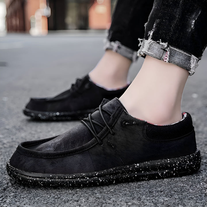 Gros plan de chaussures décontractées noires en toile portées avec un jean noir effiloché., 45286671614133,45286671646901,45286671679669,45286671712437,45286671745205,45286671777973,45286671810741,45286671843509,45286671876277,45286671909045,45286671941813,45286671974581,45286672007349,45286672040117,45286672072885,45286672105653,45286672138421,45286672171189,45286672203957,45286672236725,45286672269493,45286672302261,45286672335029,45286672367797,45286672400565,45286672433333,45286672466101,452866724