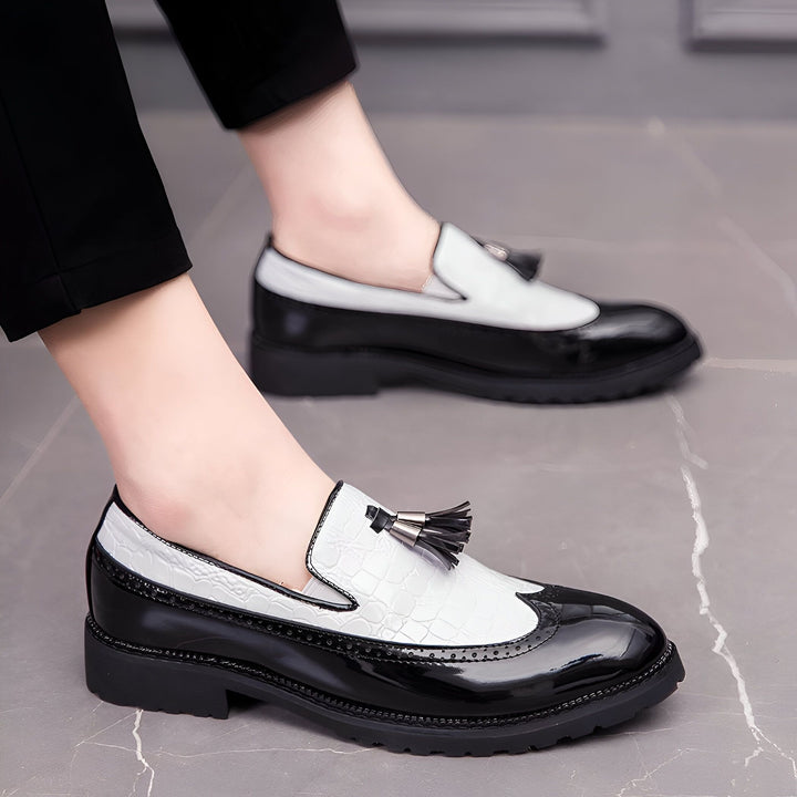 Gros plan sur des chaussures Richelieu bicolores noires et blanches, avec des glands décoratifs, portées avec un pantalon noir. Détail de la texture et du design élégant., 45287061323957,45287061356725,45287061389493,45287061422261,45287061455029,45287061487797,45287061520565,45287061553333,45287061586101