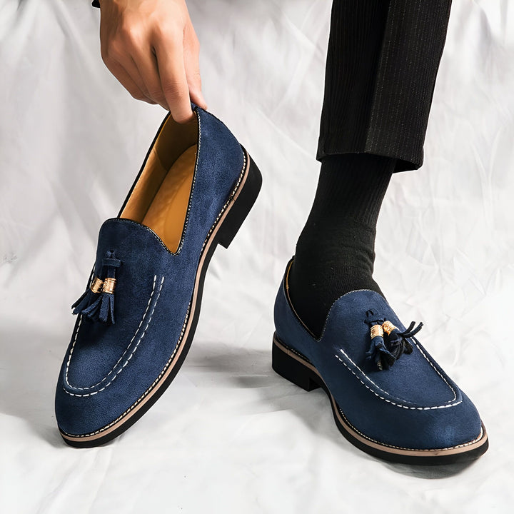 Gros plan sur des mocassins bleus à glands en daim pour homme, avec un pantalon noir à rayures fines. Style élégant et décontracté. Chaussures de ville tendance., 45287109394613,45287109427381,45287109460149,45287109492917,45287109525685,45287109558453,45287109591221,45287109623989,45287109656757,45287109689525