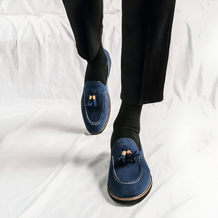 Gros plan sur des mocassins à glands bleus portés avec un pantalon noir et des chaussettes sombres. Chaussures en daim élégantes sur fond blanc texturé. Mode masculine, style décontracté chic., 45287109394613,45287109427381,45287109460149,45287109492917,45287109525685,45287109558453,45287109591221,45287109623989,45287109656757,45287109689525