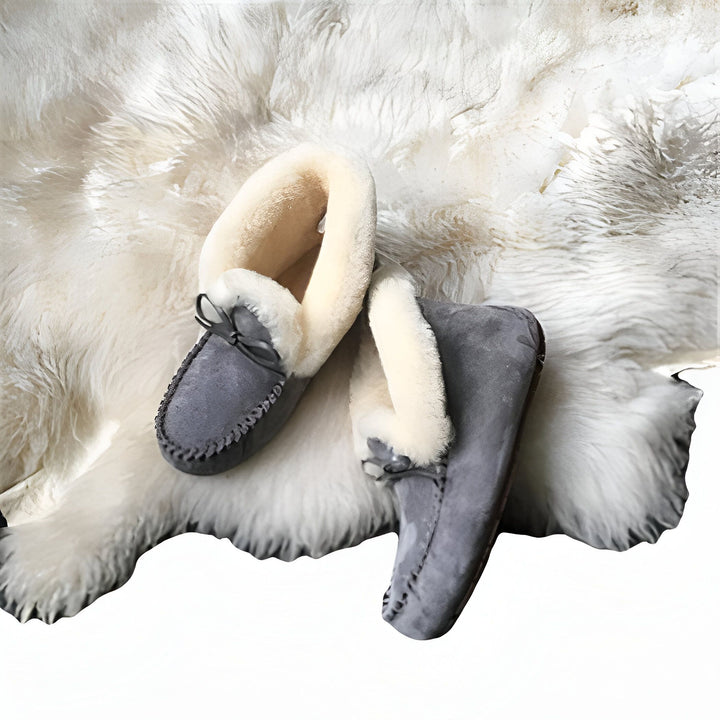 Mocassins d'intérieur gris en peau de mouton sur une peau de bête blanche et duveteuse. Chaussons confortables et chauds, parfaits pour l'hiver et la détente à la maison., 45286951452853,45286951485621,45286951518389,45286951551157,45286951583925,45286951616693,45286951649461,45286951682229,45286951714997,45286951747765,45286951780533,45286951813301,45286951846069,45286951878837,45286951911605,45286951944373,45286951977141,45286952009909,45286952042677,45286952075445,45286952108213,45286952140981,4528