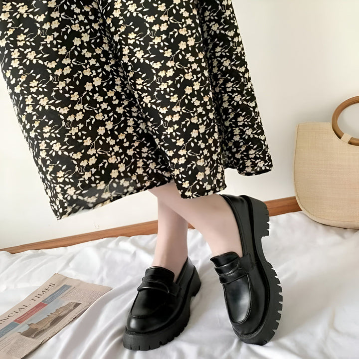 Gros plan sur des mocassins noirs portés avec une robe à fleurs, posés sur un drap blanc avec un journal et un sac en paille en arrière-plan. Style tendance et décontracté., 45286720700597,45286720733365,45286720766133,45286720798901,45286720831669,45286720864437,45286720897205,45286720929973,45286720962741