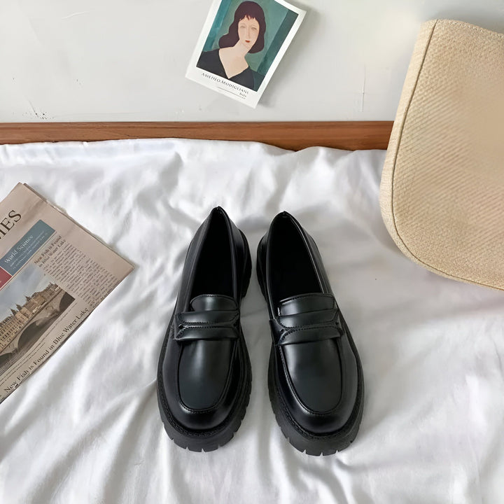 Mocassins noirs épais sur un drap blanc, avec un journal, un sac beige et une carte d'art de Modigliani en arrière-plan. Chaussures de ville tendance, style preppy., 45286720700597,45286720733365,45286720766133,45286720798901,45286720831669,45286720864437,45286720897205,45286720929973,45286720962741