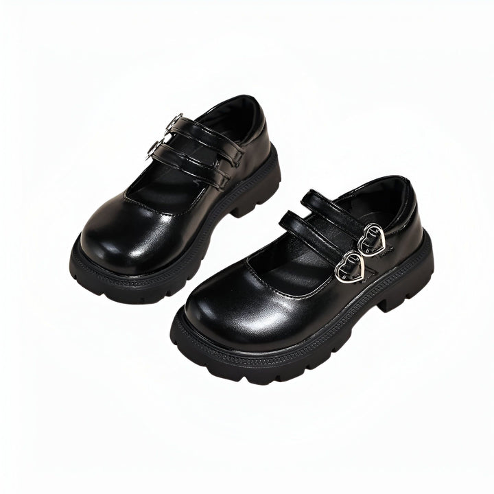 Deux chaussures Mary Jane noires vernies à semelles épaisses avec brides ajustables. Les boucles de la chaussure droite sont en forme de cœur. Chaussures tendance, élégantes et confortables., 45286684262581,45286684295349,45286684328117,45286684360885,45286684393653,45286684426421,45286684459189,45286684491957,45286684524725,45286684557493