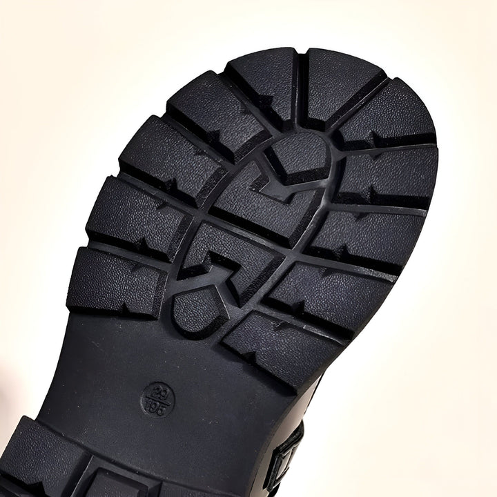 Gros plan de la semelle noire d'une botte, montrant des motifs profonds pour une bonne adhérence. Parfait pour affronter tous les terrains., 45286684262581,45286684295349,45286684328117,45286684360885,45286684393653,45286684426421,45286684459189,45286684491957,45286684524725,45286684557493
