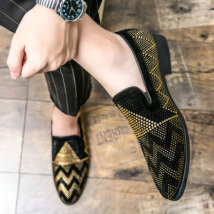 Homme portant des mocassins noirs et dorés brillants. Détail de la montre au poignet et du pantalon à rayures. Chaussures de soirée élégantes., 45287109034165,45287109066933,45287109099701,45287109132469,45287109165237,45287109198005,45287109230773,45287109263541,45287109296309,45287109329077