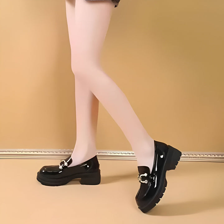 Gros plan sur des chaussures vernies noires de style mocassin portées avec des collants blancs. Chaussures à plateforme avec boucle argentée. Mode chaussures femme., 45286649397429,45286649430197,45286649462965,45286649495733,45286649528501,45286649561269