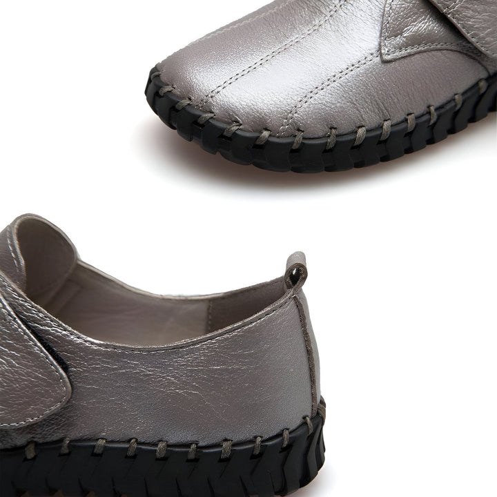 Gros plan sur une paire de chaussures en cuir argentées avec semelle noire, détail de couture visible. Chaussures confortables et modernes pour femme., 45286889914549,45286889947317,45286889980085,45286890012853,45286890045621,45286890078389,45286890111157,45286890143925,45286890176693,45286890209461,45286890242229,45286890274997,45286890307765,45286890340533,45286890373301,45286890406069,45286890438837,45286890471605,45286890504373,45286890537141,45286890569909,45286890602677,45286890635445,45286890668