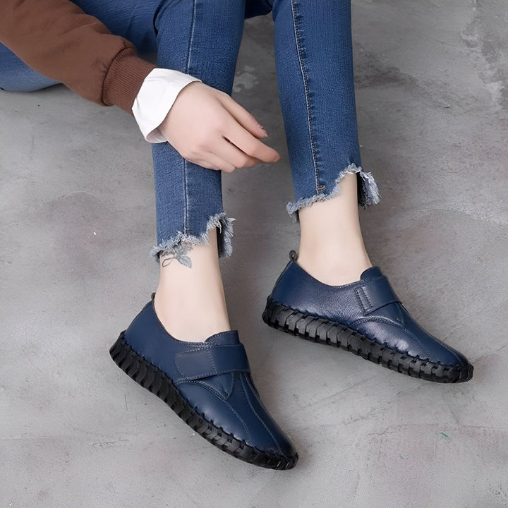 Image d'une femme assise par terre, portant un jean bleu effiloché et des chaussures bateau en cuir bleu marine avec des semelles noires épaisses. Vue rapprochée sur les chaussures et les jambes., 45286889914549,45286889947317,45286889980085,45286890012853,45286890045621,45286890078389,45286890111157,45286890143925,45286890176693,45286890209461,45286890242229,45286890274997,45286890307765,45286890340533,45286890373301,45286890406069,45286890438837,45286890471605,45286890504373,45286890537141,4528689056