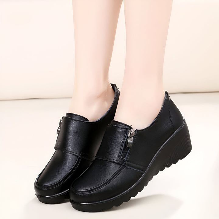 Chaussures noires compensées pour femmes, avec fermeture éclair latérale, portées par une femme. Style décontracté et confortable. Mode chaussures pour femmes., 45286892667061,45286892699829,45286892732597,45286892765365,45286892798133,45286892830901,45286892863669