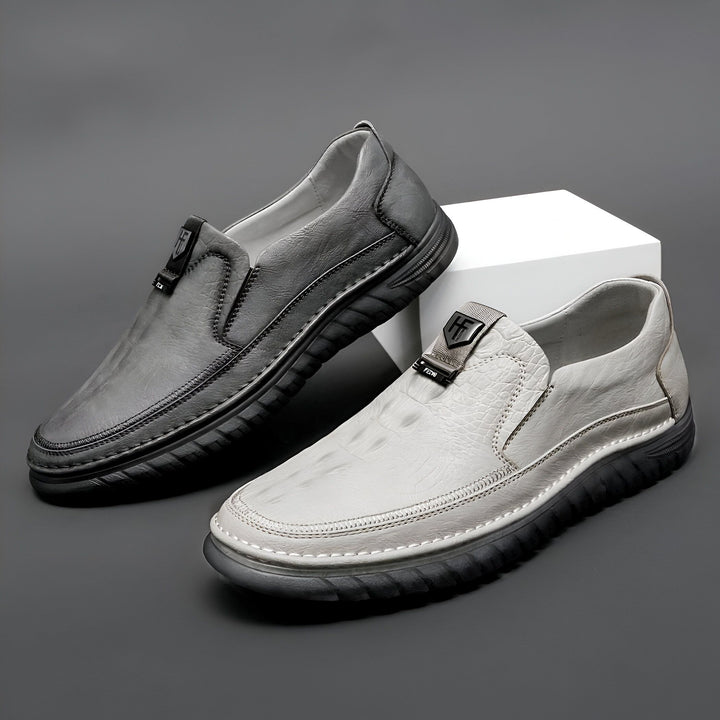 Deux mocassins pour hommes gris, un en cuir lisse, l'autre en cuir façon crocodile. Chaussures décontractées et élégantes sur fond gris., 45286747177141,45286747209909,45286747242677,45286747275445,45286747308213,45286747340981,45286747373749,45286747406517,45286747439285,45286747472053,45286747504821,45286747537589,45286747570357,45286747603125,45286747635893,45286747668661,45286747701429,45286747734197,45286747766965,45286747799733,45286747832501