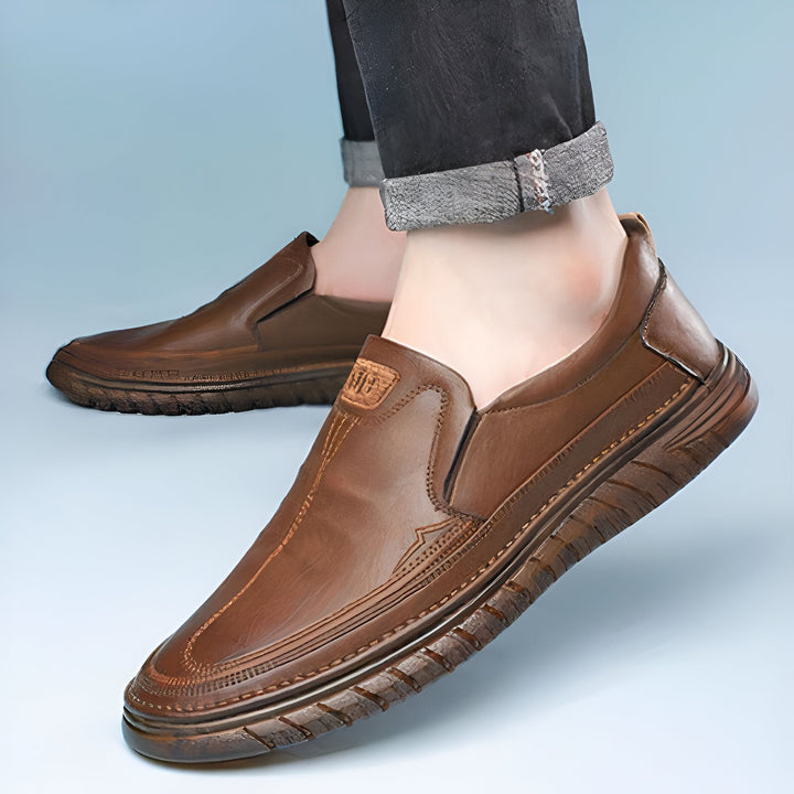 Gros plan de mocassins marron en cuir portés par un homme. Chaussures élégantes et confortables, parfaites pour un look décontracté ou professionnel. Détails de couture raffinés et semelle texturée., 45286930940085,45286930972853,45286931005621,45286931038389,45286931071157,45286931103925,45286931136693,45286931169461,45286931202229,45286931234997,45286931267765,45286931300533,45286931333301,45286931366069,45286931398837,45286931431605,45286931464373,45286931497141,45286931529909,45286931562677,45