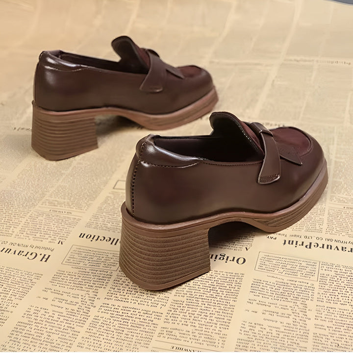 Deux chaussures de ville marron foncé avec un talon épais, posées sur une surface couverte de papier journal. Le cuir lisse contraste avec les textures du talon et du journal., 45286630883509,45286630916277,45286630949045,45286630981813,45286631014581,45286631047349,45286631080117,45286631112885,45286631145653,45286631178421,45286631211189,45286631243957,45286631276725,45286631309493