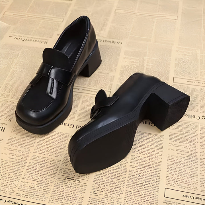Deux chaussures noires à talons épais sur un journal. Mocassins classiques avec une touche moderne. Chaussures de style collège, élégantes et confortables, parfaites pour toutes les occasions., 45286630883509,45286630916277,45286630949045,45286630981813,45286631014581,45286631047349,45286631080117,45286631112885,45286631145653,45286631178421,45286631211189,45286631243957,45286631276725,45286631309493