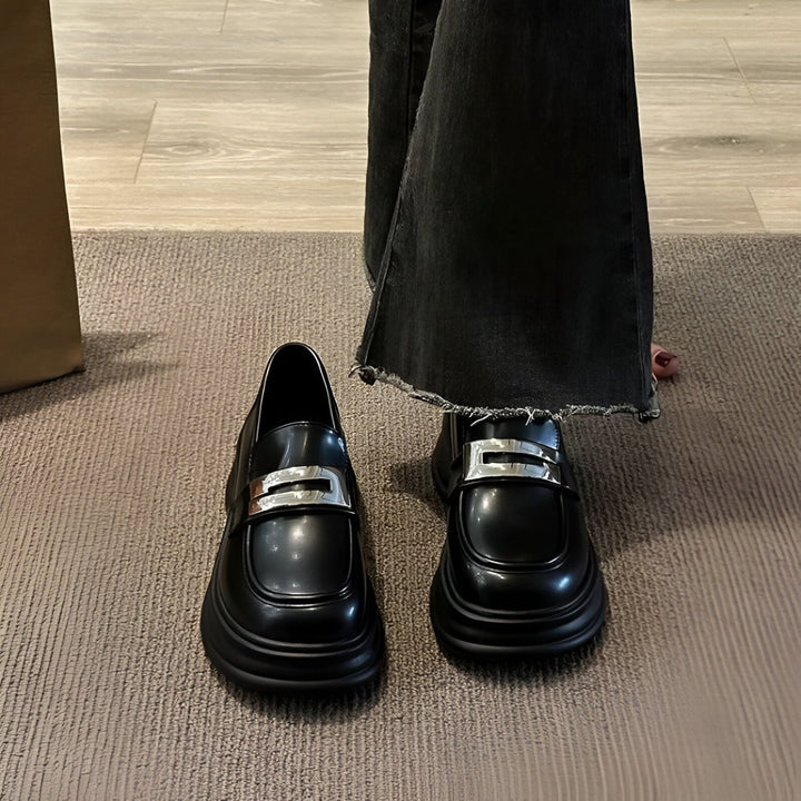 Gros plan sur des mocassins noirs avec une boucle argentée, portés avec un jean noir. Chaussures à plateforme tendance, style preppy. Mode automne-hiver., 45286686064821,45286686097589,45286686130357,45286686163125,45286686195893,45286686228661,45286686261429,45286686294197,45286686326965,45286686359733