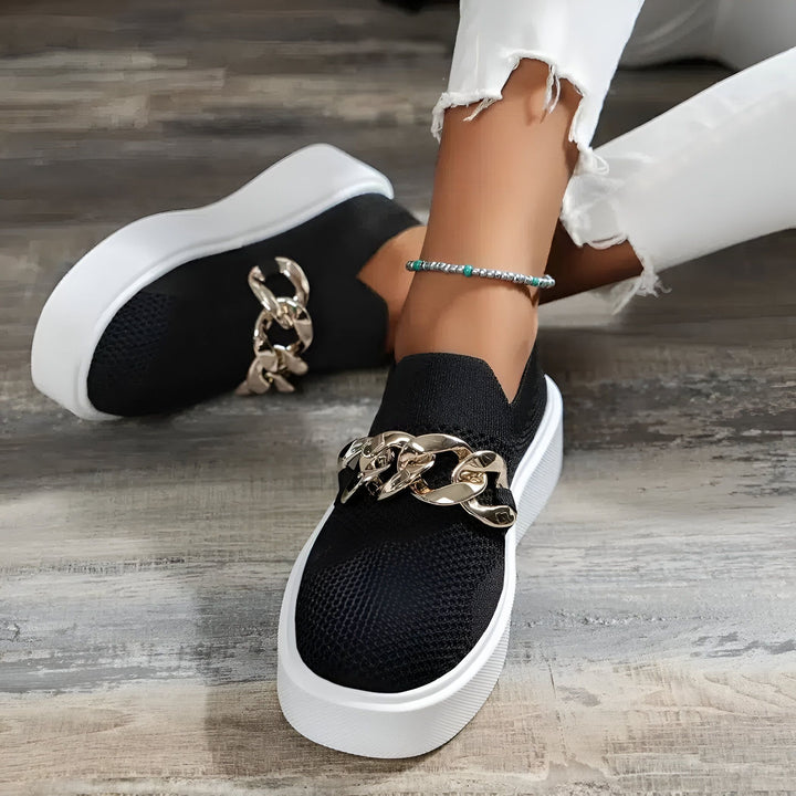 Gros plan sur des baskets noires à semelles blanches avec une chaîne dorée décorative. Une femme porte un jean blanc effiloché et une chaîne de cheville., 45286881886389,45286881919157,45286881951925,45286881984693,45286882017461,45286882050229,45286882082997,45286882115765,45286882148533,45286882181301,45286882214069,45286882246837,45286882279605,45286882312373,45286882345141,45286882377909,45286882410677,45286882443445,45286882476213,45286882508981,45286882541749,45286882574517,45286882607285,4528