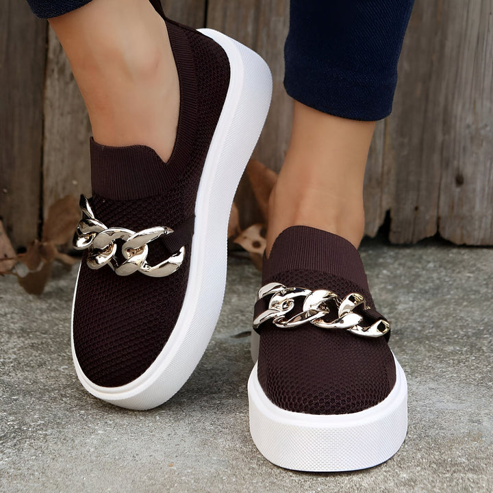 Chaussures de sport marron sans lacets avec semelles blanches et décorations de chaîne argentées portées par une personne., 45286881886389,45286881919157,45286881951925,45286881984693,45286882017461,45286882050229,45286882082997,45286882115765,45286882148533,45286882181301,45286882214069,45286882246837,45286882279605,45286882312373,45286882345141,45286882377909,45286882410677,45286882443445,45286882476213,45286882508981,45286882541749,45286882574517,45286882607285,45286882640053,45286882672821,4528688