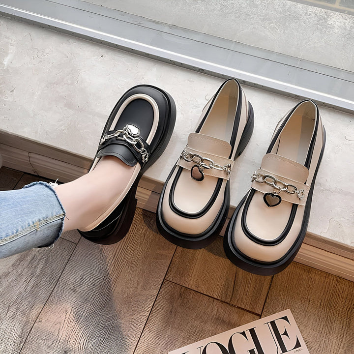 Mocassins tendance à plateforme, décorés de chaînes et d'un cœur, présentés aux côtés d'un magazine Vogue. Chaussures bicolores, idéales pour un look moderne et élégant. Détail mode avec une jambe portant un jean., 45286956630197,45286956662965,45286956695733,45286956728501,45286956761269,45286956794037,45286956826805,45286956859573,45286956892341,45286956925109,45286956957877,45286956990645,45286957023413,45286957056181