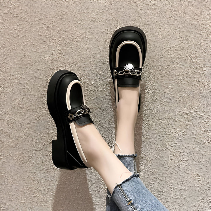 Gros plan de chaussures mocassins noires à plateforme et à chaîne argentée avec un cœur, portées avec un jean décontracté. Mode automne-hiver., 45286956630197,45286956662965,45286956695733,45286956728501,45286956761269,45286956794037,45286956826805,45286956859573,45286956892341,45286956925109,45286956957877,45286956990645,45286957023413,45286957056181