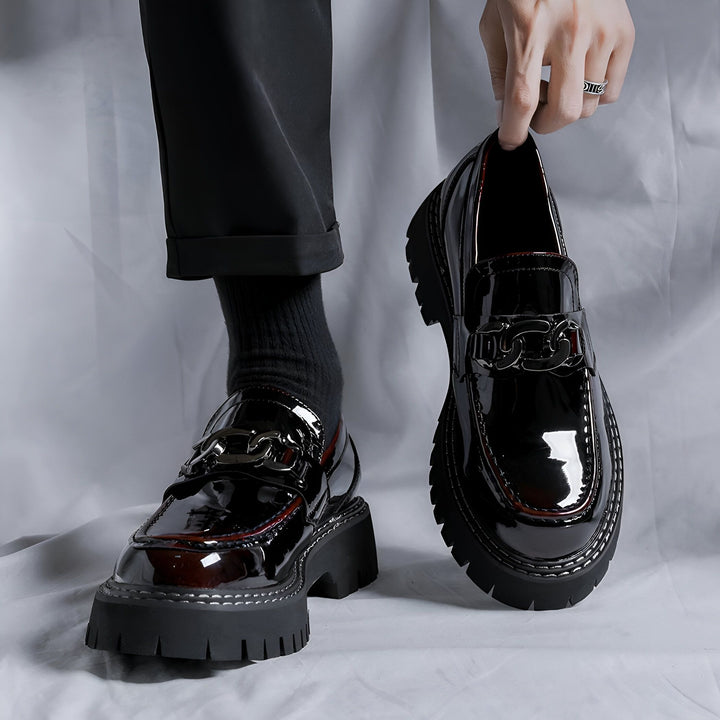 Mocassins vernis noirs avec semelle plateforme et chaîne décorative. Chaussures de mode pour hommes, style élégant et tendance. Gros plan sur une paire, un homme tient une chaussure à la main., 45286900367541,45286900400309,45286900433077,45286900465845,45286900498613,45286900531381,45286900564149
