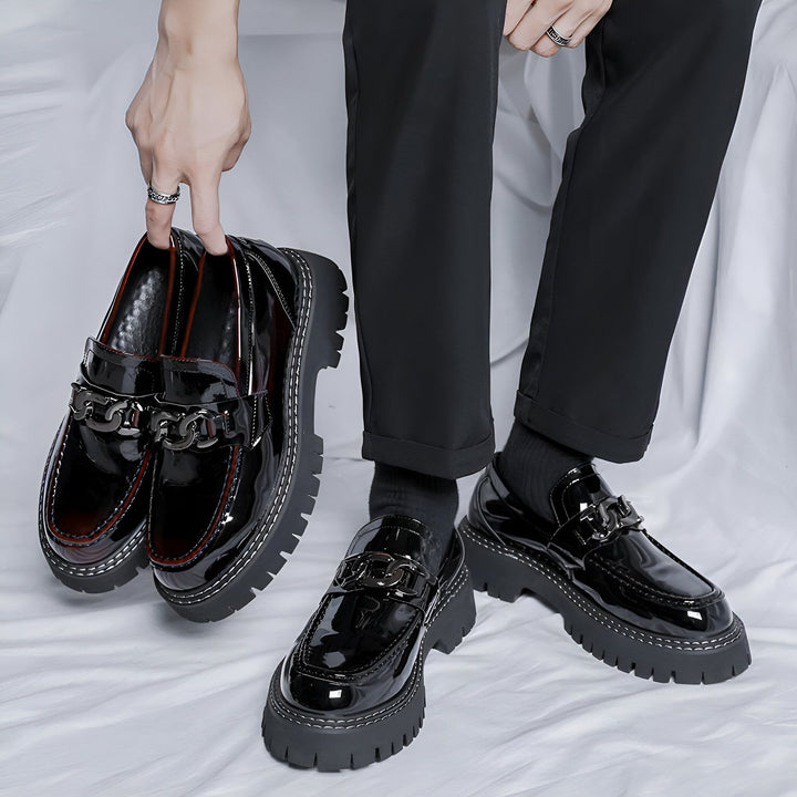Mocassins vernis noirs à plateforme, portés par un homme avec un pantalon noir. Détail de chaîne métallique sur les chaussures. Mode masculine élégante et audacieuse., 45286900367541,45286900400309,45286900433077,45286900465845,45286900498613,45286900531381,45286900564149