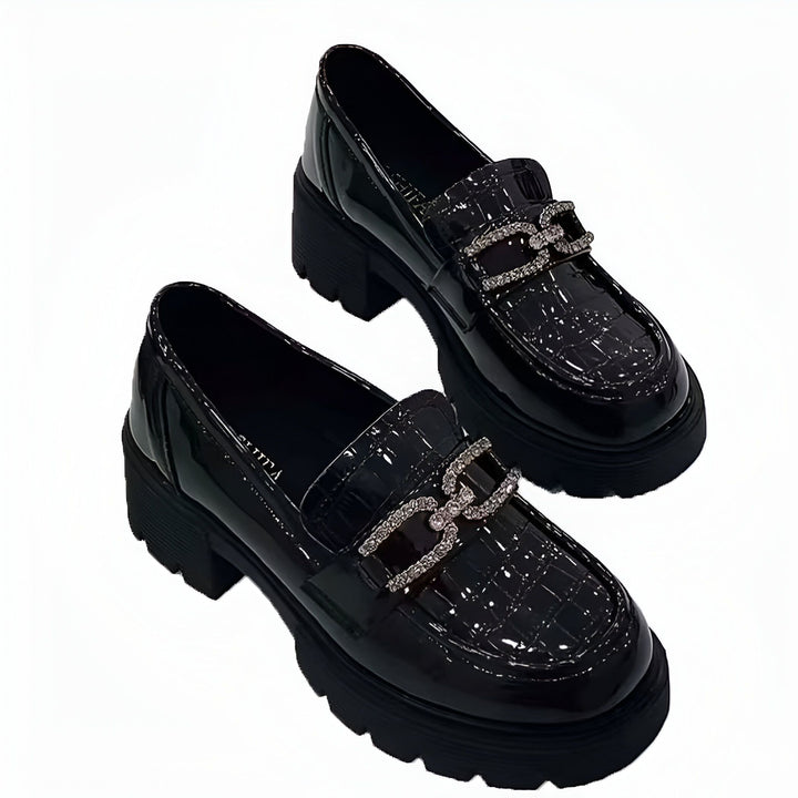 Deux mocassins noirs vernis avec une boucle ornée de strass sur le dessus. Ces chaussures élégantes ont une semelle épaisse. Mode féminine, chaussures à la mode., 45286630228149,45286630260917,45286630293685,45286630326453,45286630359221,45286630391989,45286630424757