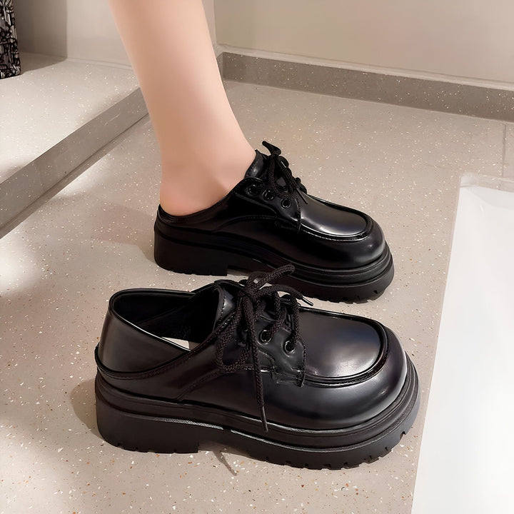 Image de deux chaussures mules noires à lacets avec semelles épaisses. Une des chaussures est portée au pied. Mode féminine, chaussures tendance., 45286834995381,45286835028149,45286835060917,45286835093685,45286835126453,45286835159221,45286835191989,45286835224757,45286835257525,45286835290293,45286835323061,45286835355829