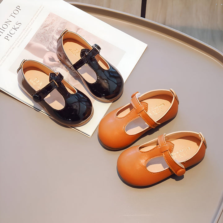 Deux paires d'adorables chaussures pour enfants, une noire vernie et l'autre marron, posées sur une table avec un magazine. Chaussures élégantes pour petites filles., 45287037894837,45287037927605,45287037960373,45287037993141,45287038025909,45287038058677,45287038091445,45287038124213,45287038156981,45287038189749,45287038222517,45287038255285,45287038288053,45287038320821,45287038353589,45287038386357,45287038419125,45287038451893,45287038484661,45287038517429