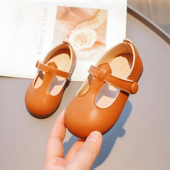 Chaussures Mary Jane marron pour enfants avec une bride à boucle, présentées avec un livre de mode en arrière-plan., 45287037894837,45287037927605,45287037960373,45287037993141,45287038025909,45287038058677,45287038091445,45287038124213,45287038156981,45287038189749,45287038222517,45287038255285,45287038288053,45287038320821,45287038353589,45287038386357,45287038419125,45287038451893,45287038484661,45287038517429
