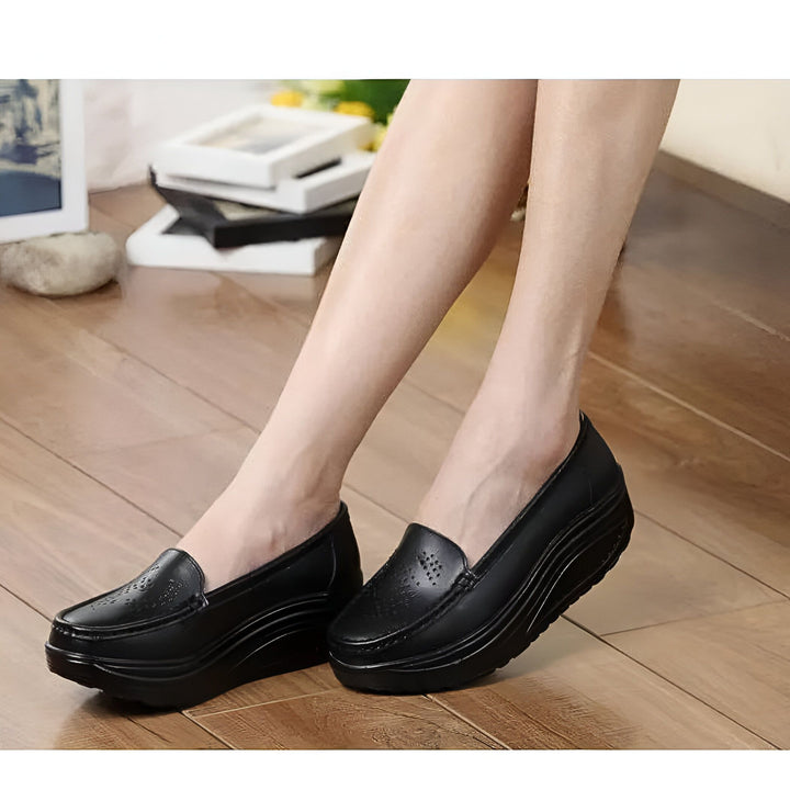Mocassins compensés noirs en cuir portés par une femme. Chaussures élégantes et confortables avec une semelle compensée. Idéal pour un look décontracté et professionnel., 45286728630453,45286728663221,45286728695989,45286728728757,45286728761525,45286728794293,45286728827061,45286728859829,45286728892597,45286728925365,45286728958133,45286728990901,45286729023669,45286729056437,45286729089205,45286729121973,45286729154741,45286729187509,45286729220277,45286729253045,45286729285813,45286729318581,4