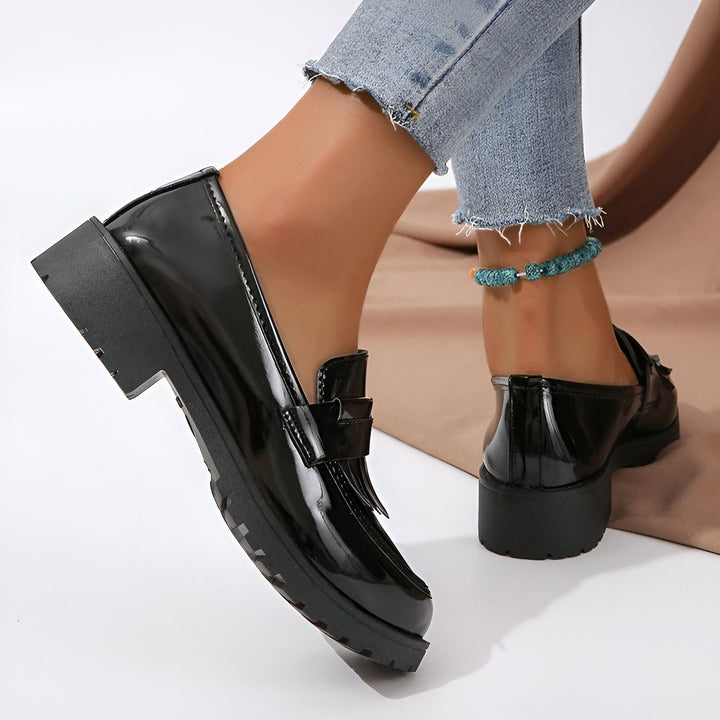 Gros plan de mocassins noirs vernis à plateforme portés avec un jean effiloché et une chaîne de cheville turquoise. Chaussures tendance et confortables., 45286687310005,45286687342773,45286687375541,45286687408309,45286687441077,45286687473845,45286687506613,45286687539381,45286687572149,45286687604917,45286687637685,45286687670453,45286687703221,45286687735989
