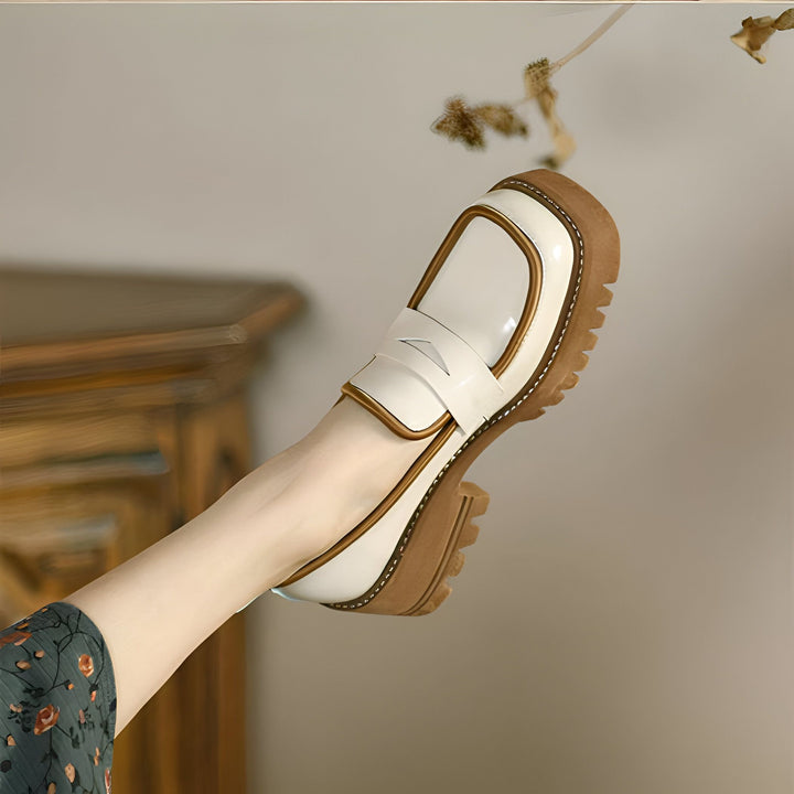 Gros plan d'un pied portant une chaussure Richelieu compensée en cuir verni blanc cassé et marron. La chaussure a une semelle épaisse et crantée. Style vintage et élégant., 45286885982389,45286886015157,45286886047925,45286886080693,45286886113461,45286886146229,45286886178997,45286886211765,45286886244533,45286886277301,45286886310069,45286886342837