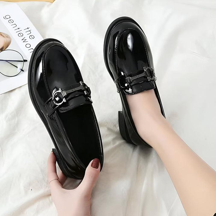 Mocassins noirs vernis pour femmes, avec boucle décorative. Chaussures élégantes, parfaites pour le travail ou une occasion spéciale. À côté, un magazine et des lunettes., 45286626295989,45286626328757,45286626361525,45286626394293,45286626427061