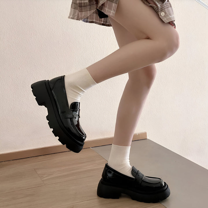 Une femme portant des mocassins noirs vernis à plateforme avec des chaussettes blanches. Elle porte une jupe à carreaux. Les chaussures sont mises en valeur., 45286831095989,45286831128757,45286831161525,45286831194293,45286831227061,45286831259829,45286831292597,45286831325365,45286831358133,45286831390901