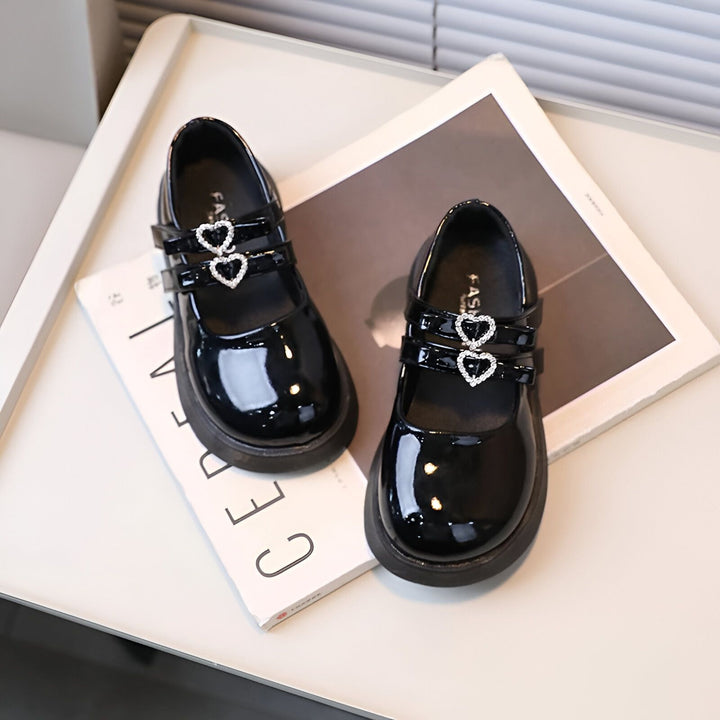 Deux chaussures vernies noires pour fille, décorées de cœurs brillants, posées sur un livre. Chaussures élégantes pour enfant, style Mary Jane., 45286682820789,45286682853557,45286682886325,45286682919093,45286682951861,45286682984629,45286683017397,45286683050165,45286683082933,45286683115701,45286683148469,45286683181237,45286683214005,45286683246773,45286683279541,45286683312309,45286683345077,45286683377845,45286683410613,45286683443381,45286683476149,45286683508917