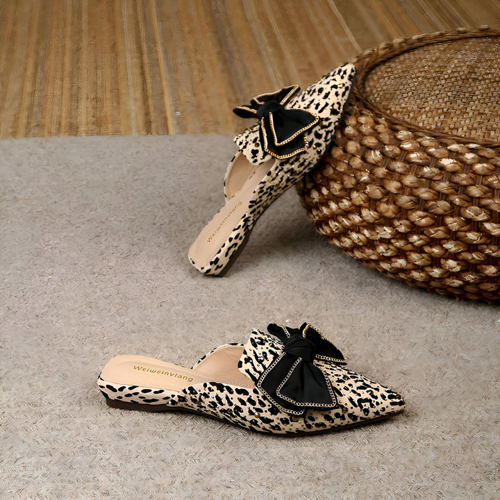 Mules à motif léopard avec noeud noir, posées sur un sol beige à côté d'un panier en osier. Chaussures élégantes de la marque Weiweinvlang., 45287150813365,45287150846133,45287150878901,45287150911669,45287150944437,45287150977205,45287151009973,45287151042741